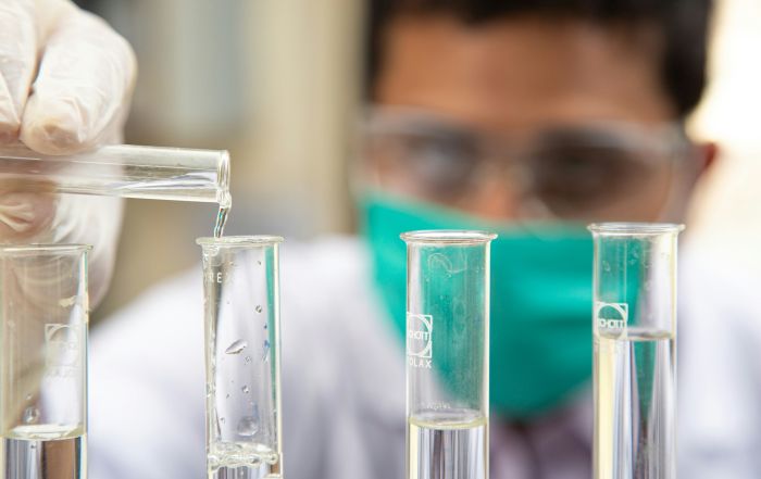 Cost of a bad hire: image depicts a scientist pouring a chemical into a test tube.